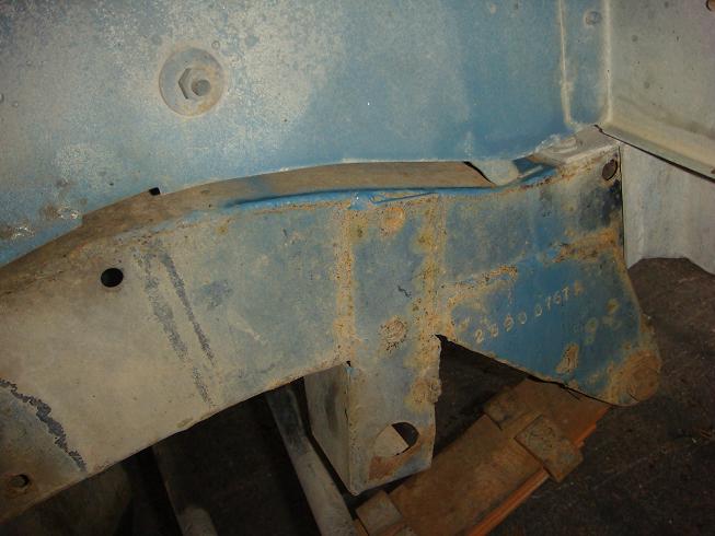 Close-up of blue painted metal frame with rust and a stamped number 2550 0767