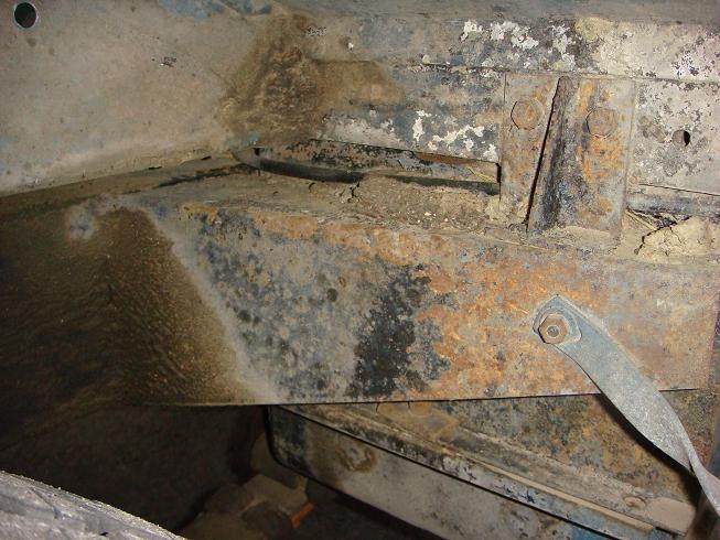 Close-up of heavily rusted metal frame and brackets on a vehicle