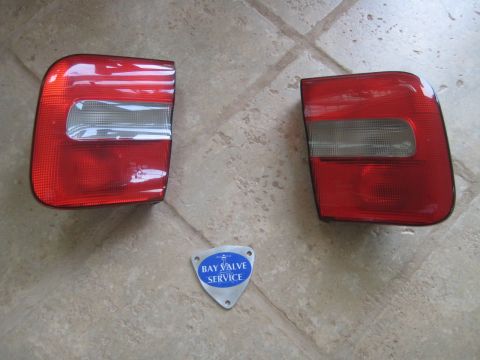 1993 Ford Probe - Two red taillights are displayed on a tiled surface next to a service badge.