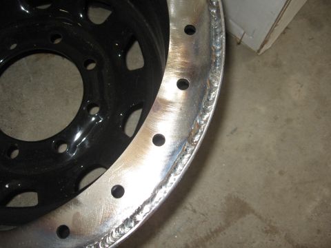 1979 Ford F-150 - A close-up view of a custom welded wheel rim, showing the raw metal and bolt pattern.
