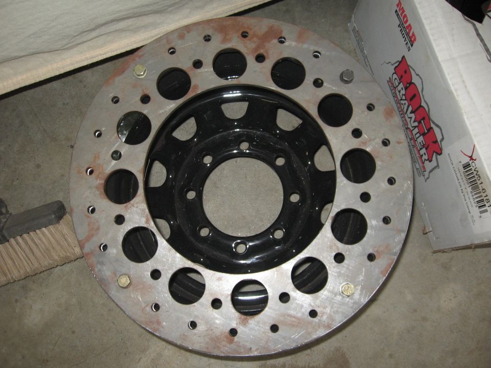 Custom drilled brake rotor with black wheel, text on box reads Rock Crawler