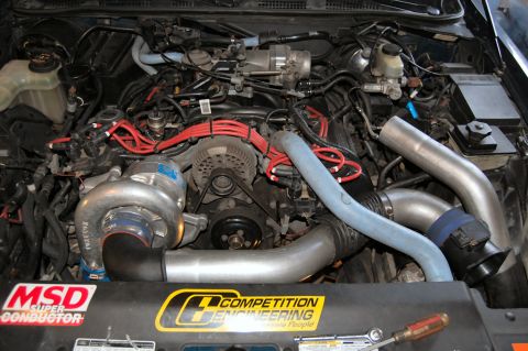 1985 Mercury Grand Marquis - Engine bay features a turbocharger and aftermarket performance parts, with visible branding stickers.
