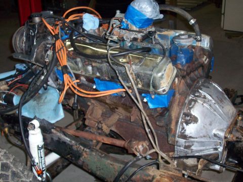 1978 Jeep CJ5 - Close-up view of a vehicle engine, orange spark plug wires and blue tape covering the carburetor.