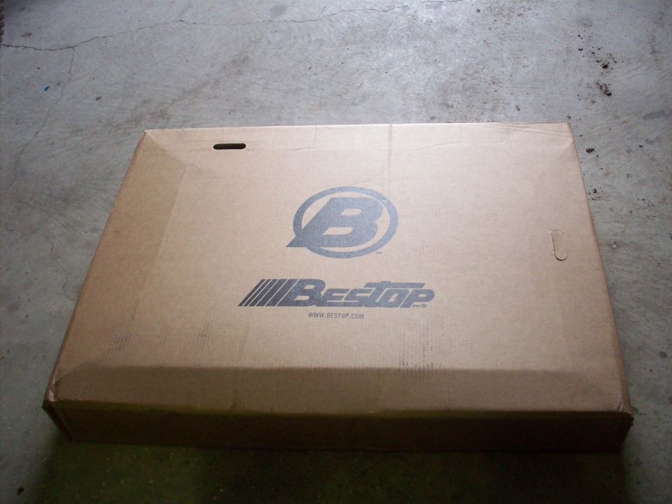Cardboard box with Bestop logo and website address, lying flat on a concrete surface