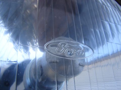 1973 Ford Ranchero - Close-up of a Ford headlight assembly, showing the brand emblem.