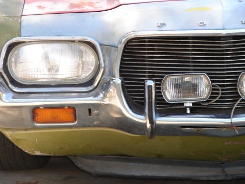 1973 Ford Ranchero - The front end of a 1972 Ford Ranchero shows a damaged chrome bumper and a horizontal grille.