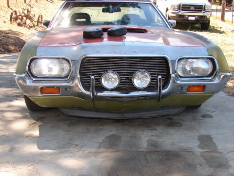 1973 Ford Ranchero - Front end of a 1970s Ford Ranchero, showing custom modifications and a second vehicle in the background.