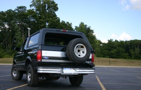 1995 Ford Bronco - Rear view of a black Ford Bronco with a spare tire mounted externally.