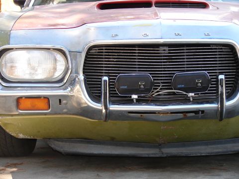 1973 Ford Ranchero - The front grille and bumper assembly of a vintage vehicle, aftermarket lights.