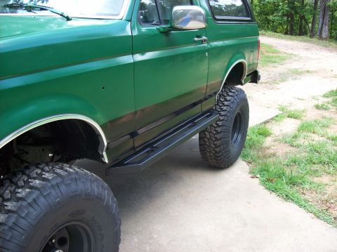 1992 Ford Bronco - This 1992 Ford Bronco features large off-road tires and custom side steps, enhancing its appearance.