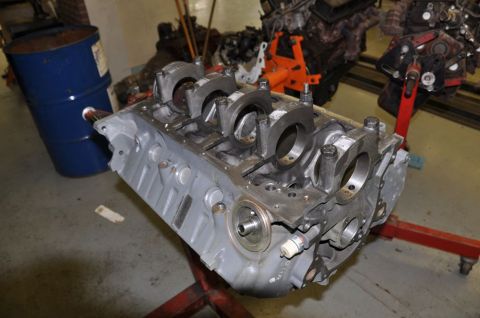 1996 Ford Bronco - An engine block, likely undergoing repair or rebuild, is positioned on a stand in a workshop setting.