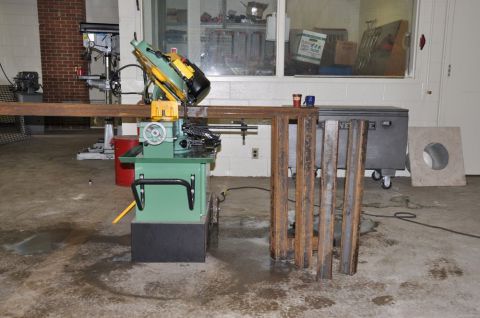 1996 Ford Bronco - A metal cutting saw is set up in a workshop with various metal pieces.