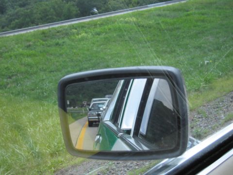 1991 Ford Crown Victoria - Traffic jam viewed through a car's side mirror on a sunny day.