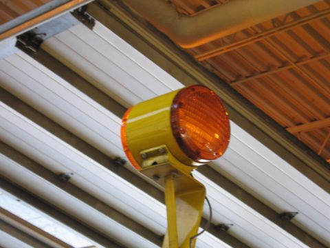 1991 Ford Crown Victoria - A yellow warning light with an orange lens is visible, mounted on a yellow pole against a background of white and orange ceiling panels.