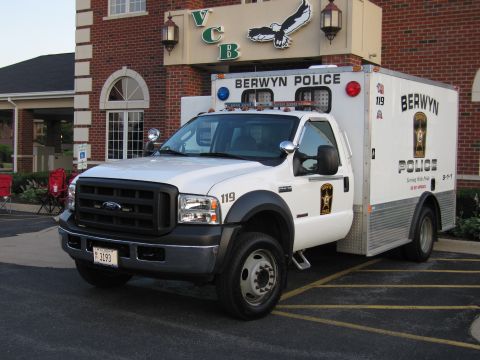 1991 Ford Crown Victoria - A Berwyn Police truck is parked in front of a building with the letters VCB and an eagle emblem.