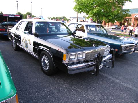 1991 Ford Crown Victoria - Two police cars, one a 1991 Ford Crown Victoria, are parked side-by-side.