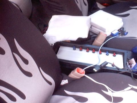 1999 Ford Taurus - The photo shows the interior of a car with custom seat covers and a device with indicator lights.