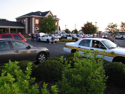 1991 Ford Crown Victoria - Several police cars, including a 1991 Ford Crown Victoria, are parked in a lot with other vehicles.