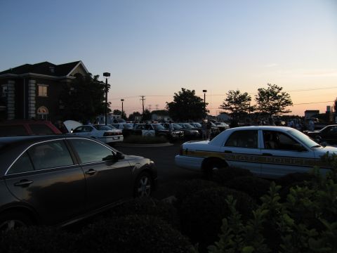1991 Ford Crown Victoria - A police car with 'STATE POLICE' text is parked in a lot with other vehicles as the sun sets.