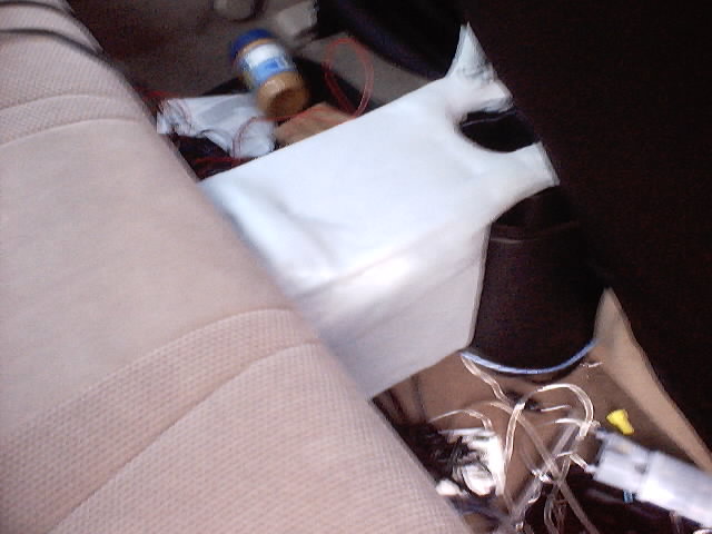Car interior with tan fabric seats, a jar of peanut butter, and electrical wiring visible