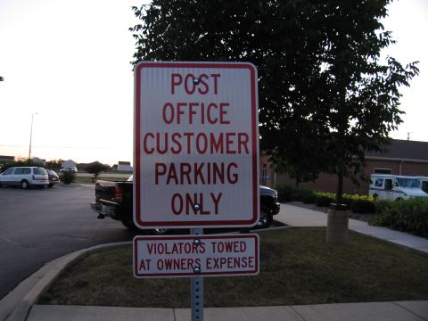 1991 Ford Crown Victoria - Signage indicates customer parking restrictions at a post office, with several vehicles visible in the background.