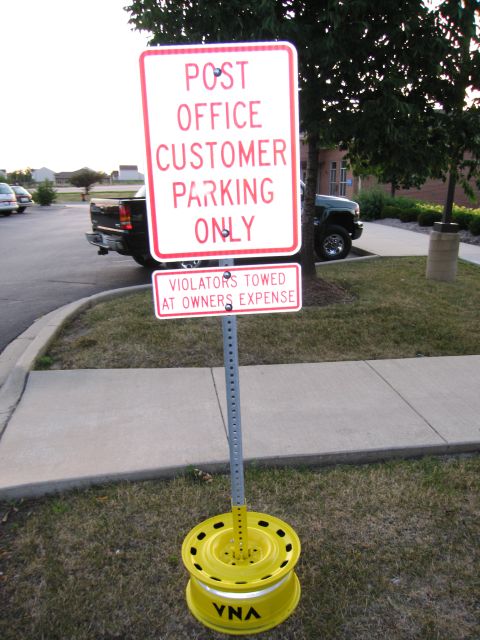 1991 Ford Crown Victoria - A sign indicates that parking is for post office customers only, with violators subject to towing.