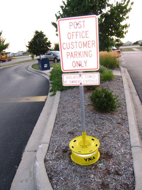 1991 Ford Crown Victoria - A silver SUV is parked near a post office with customer parking signs.