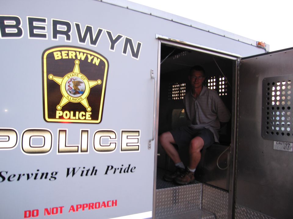 White Berwyn Illinois Police prisoner-transport van with a man seated inside the open rear