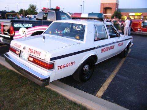 1991 Ford Crown Victoria - A white police car with "WOOD DALE POLICE" markings is parked next to another police vehicle.