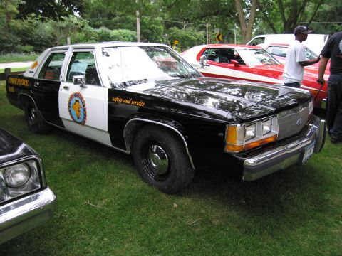 1991 Ford Crown Victoria - This 1991 Ford Crown Victoria police car features a two-tone black and white paint scheme and "safety and service" text on the fender.