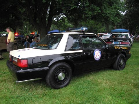 1991 Ford Crown Victoria - This Florida Highway Patrol car is parked on grass with other vehicles and people in the background.