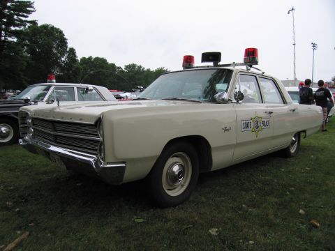 1991 Ford Crown Victoria - This Plymouth police car features dual red lights and "STATE POLICE" markings on the door.