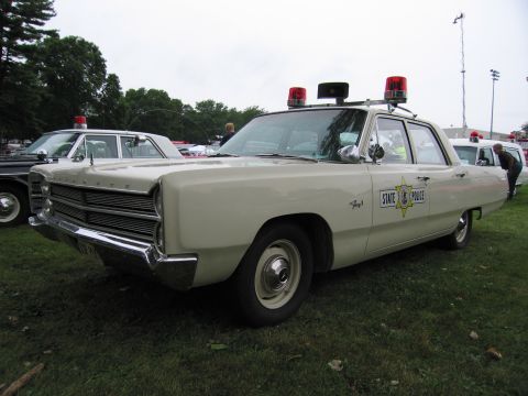 1991 Ford Crown Victoria - A vintage state police car with "STATE POLICE" text and a star emblem on the door is displayed outdoors.