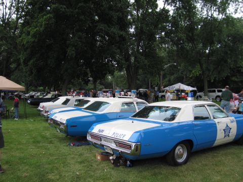 1991 Ford Crown Victoria - Several vintage police cars, likely from the 1970s, are lined up on display at an outdoor event.