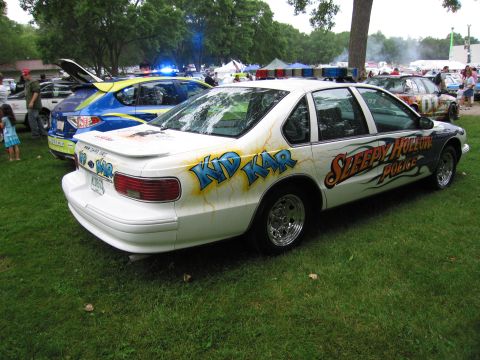 1991 Ford Crown Victoria - Customized police car with 'Kid Kar' and 'Sleepy Hollow Police' graphics is parked on grass.