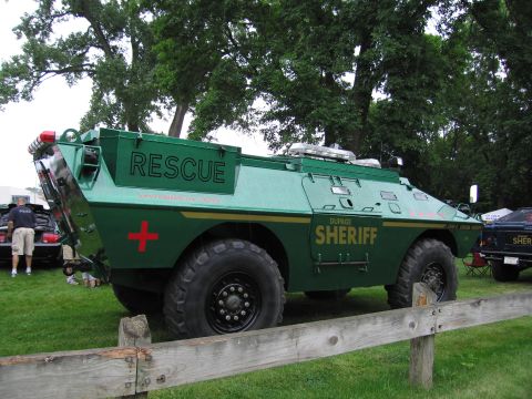1991 Ford Crown Victoria - A large green armored vehicle marked "RESCUE" and "DUPAGE SHERIFF" is parked on a grassy field.