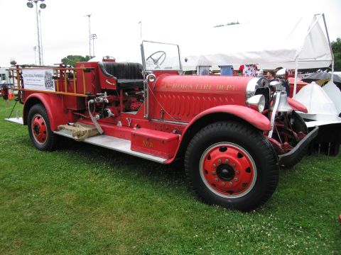 1991 Ford Crown Victoria - This vintage fire truck, marked for the Aurora Fire Dept., is on display on a grassy field.