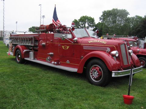 1991 Ford Crown Victoria - Vintage red fire truck with an American flag flying proudly.