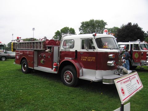 1991 Ford Crown Victoria - This American LaFrance fire truck is displayed on a grassy field next to another fire truck.