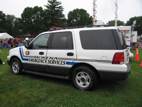 1991 Ford Crown Victoria - White SUV with emergency markings parked on grass.