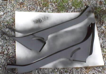 1999 Ford Taurus - Two gray car interior trim pieces are laid out on a white sheet, possibly for painting or modification.