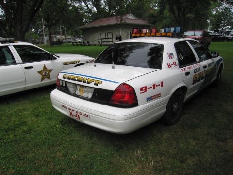 1991 Ford Crown Victoria - Two sheriff's department vehicles, one a K-9 unit, are parked on a grassy area.
