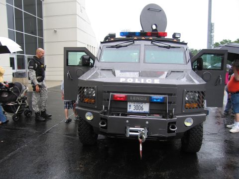 1991 Ford Crown Victoria - A Lenco armored vehicle with police markings is parked outside on a wet day.