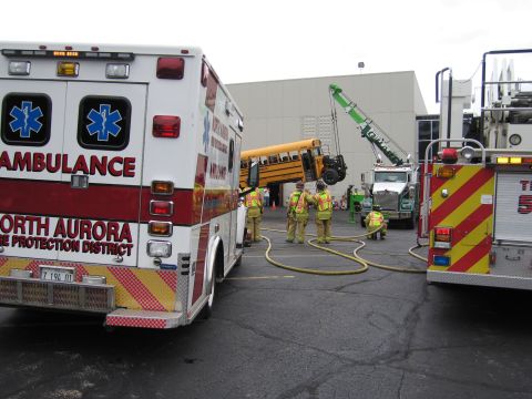 1991 Ford Crown Victoria - Emergency vehicles and personnel respond to an incident involving a school bus being lifted by a crane.