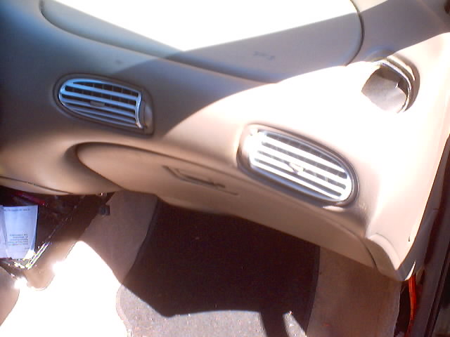 Tan dashboard panel with two oval air vents and chrome louvers removed from the car