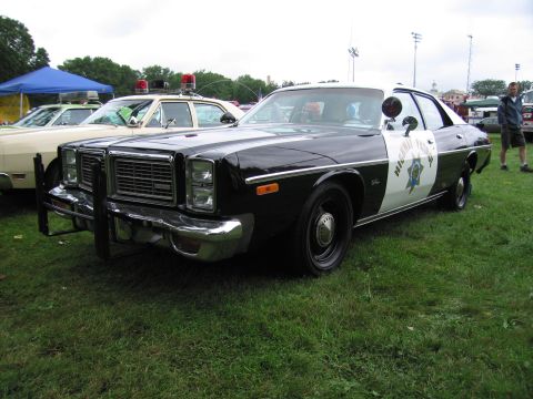 1991 Ford Crown Victoria - This police car, likely a 1977 model, is parked on grass next to another vehicle.