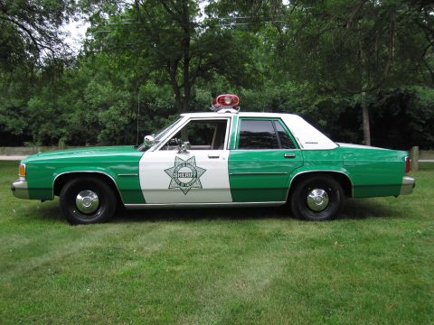 1991 Ford Crown Victoria - This 1991 Ford Crown Victoria, painted in green and white, is equipped as a sheriff's vehicle with a light bar on the roof.