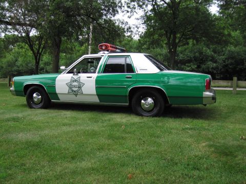 1991 Ford Crown Victoria - This 1991 Ford Crown Victoria, painted in a distinctive green and white livery, is marked with a sheriff's department star emblem.