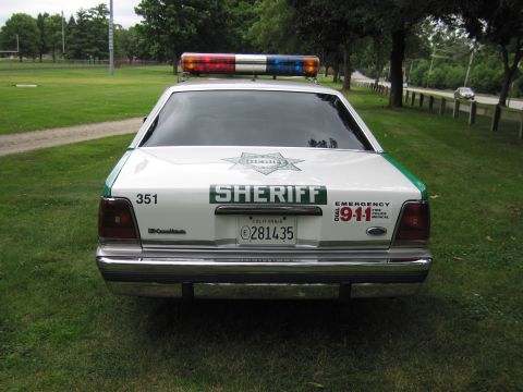 1991 Ford Crown Victoria - Rear view of a 1991 Ford Crown Victoria police car, marked "SHERIFF" and equipped with a light bar.