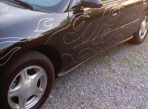 1999 Ford Taurus - This car has custom flame graphics on its side.